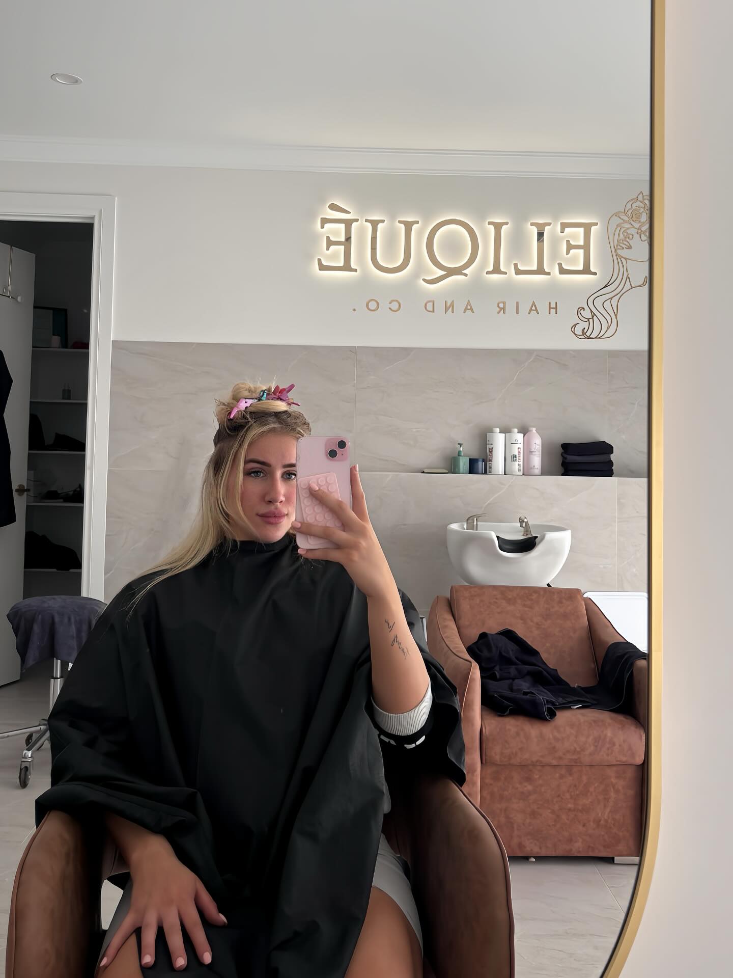 Inside the Eliqué Hair and Co. studio, with the lit signage