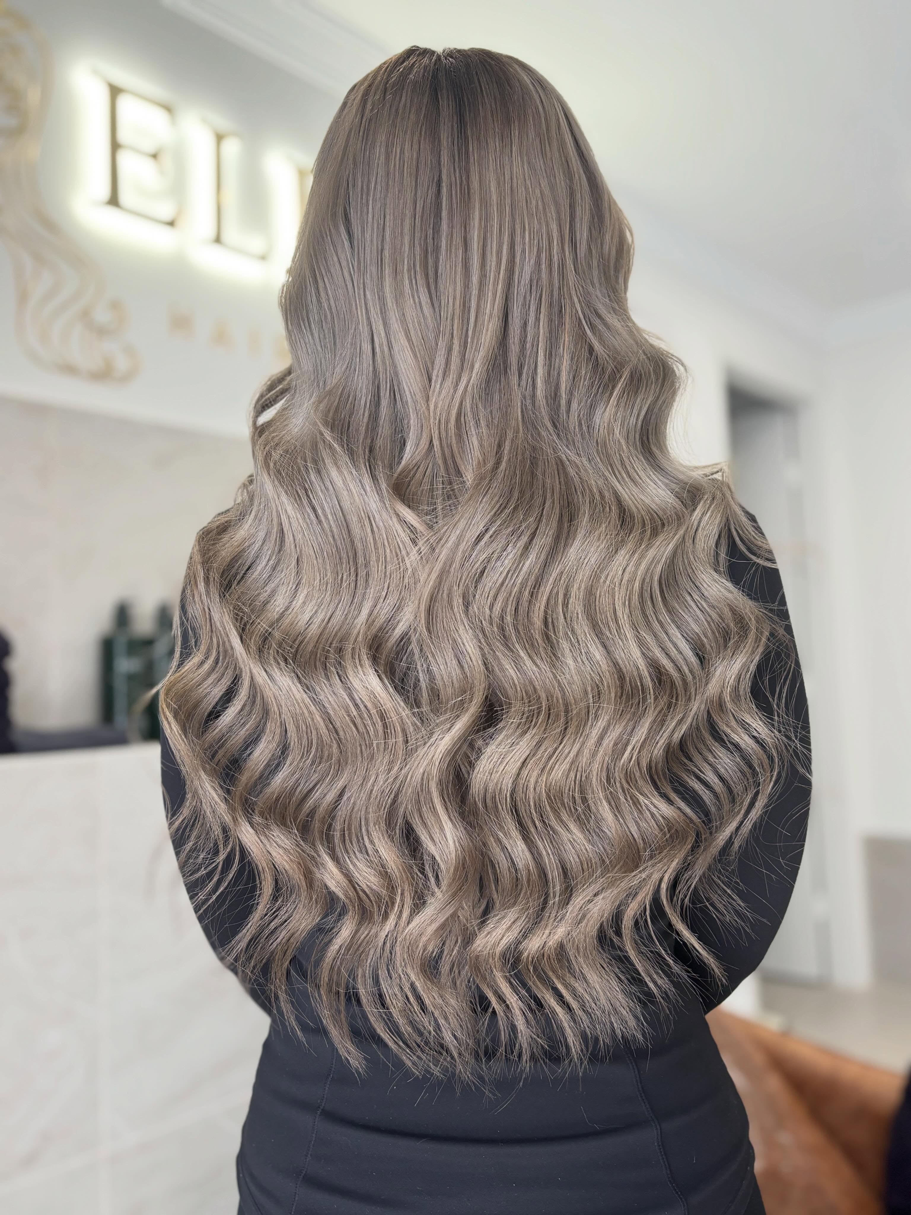Long glossy bronde waves styled at Eliqué Hair and Co.